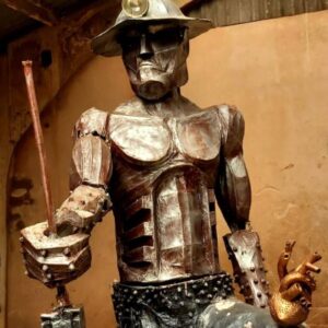 an image of a stylised golden brown sculpture of a Cornish miner made of tin at Geevor Mine World Heritage Site in Cornwall.
