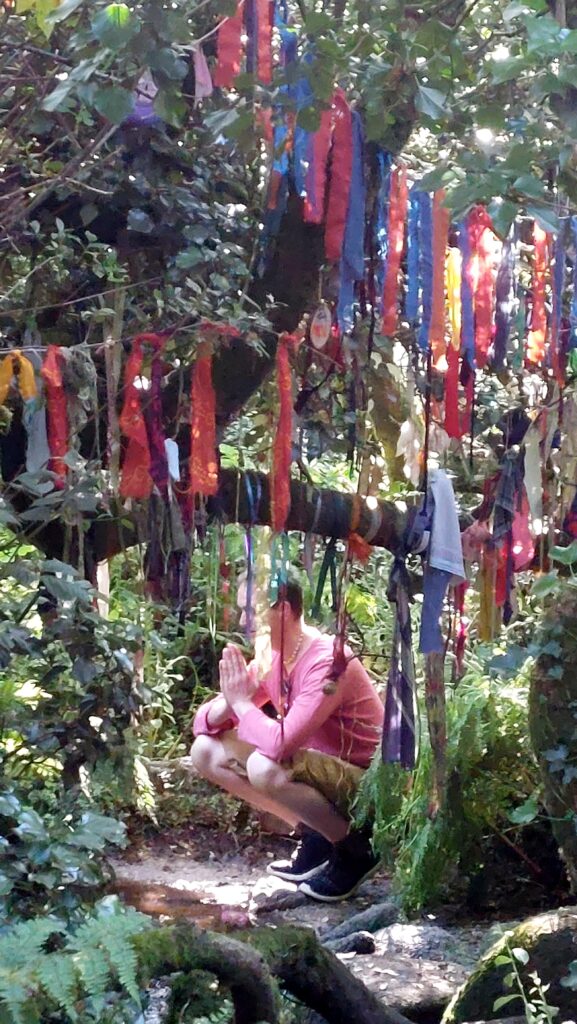 clooties hanging from branches of trees, obscuring a person in pink